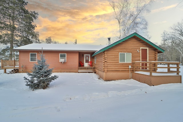 snow covered house featuring a deck