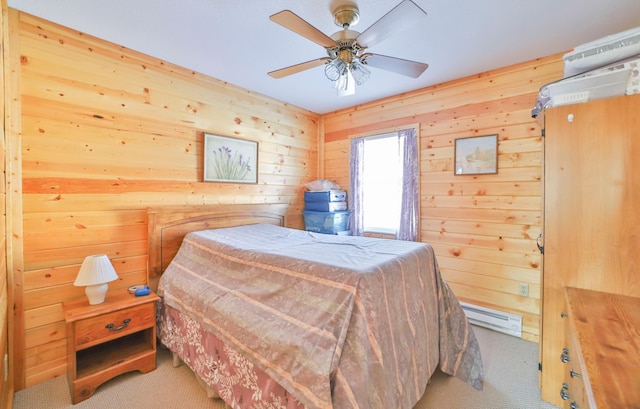 bedroom featuring wooden walls, carpet floors, baseboard heating, and a ceiling fan