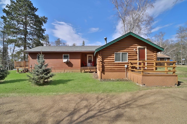 view of front of house with a front lawn, a wooden deck, and log exterior