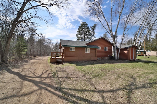 view of home's exterior with an outbuilding, a yard, and a storage shed
