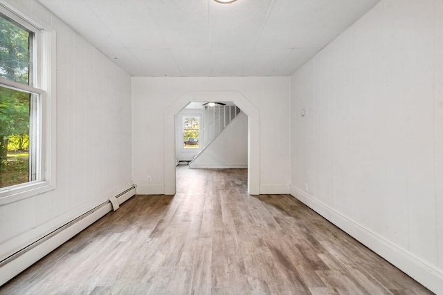 bonus room featuring a baseboard heating unit and light wood-type flooring