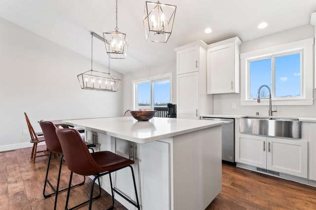 kitchen with dishwasher, white cabinets, hanging light fixtures, and a center island