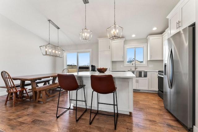 kitchen featuring white cabinetry, appliances with stainless steel finishes, sink, hanging light fixtures, and a center island