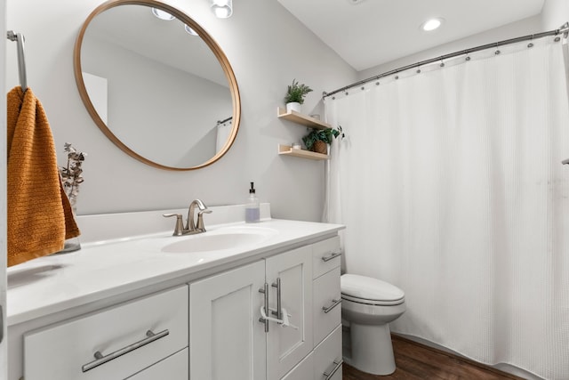 bathroom with toilet, vanity, and hardwood / wood-style floors