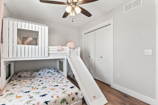 bedroom with ceiling fan, dark wood-type flooring, and a closet