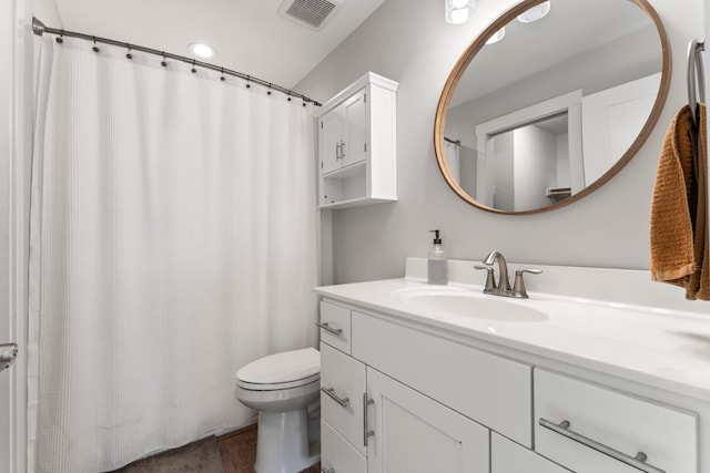 bathroom featuring toilet, wood-type flooring, and vanity