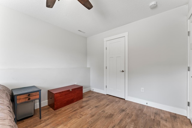 bedroom featuring ceiling fan, a textured ceiling, and hardwood / wood-style flooring