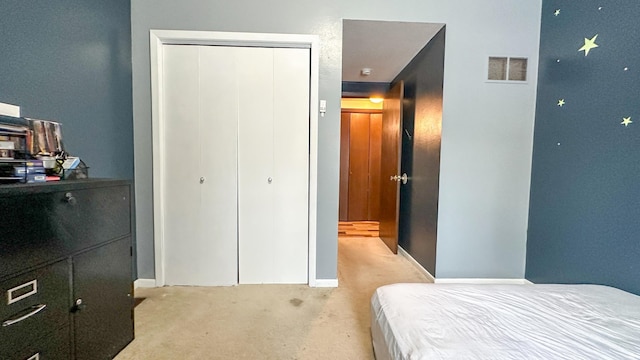 bedroom with light colored carpet and a closet