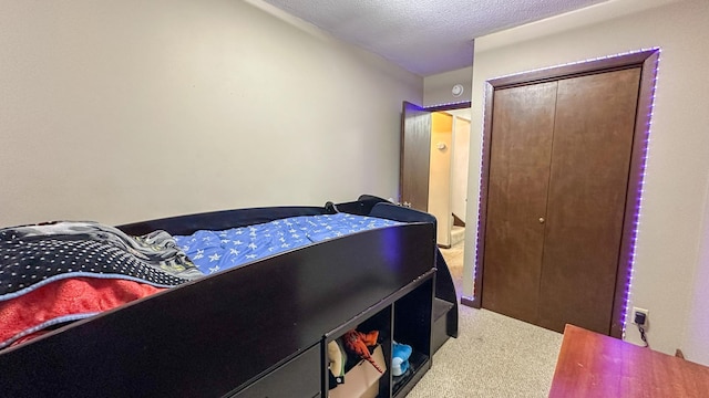 bedroom with a textured ceiling, a closet, and carpet flooring