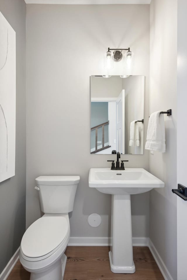 bathroom with sink, hardwood / wood-style floors, and toilet