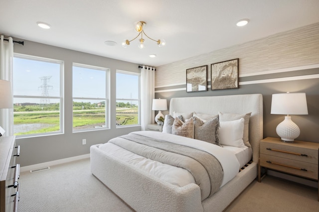 carpeted bedroom featuring a notable chandelier