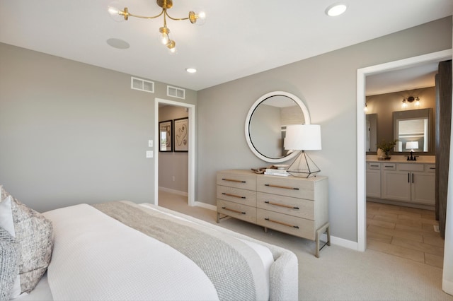 bedroom with sink, ensuite bathroom, and light carpet