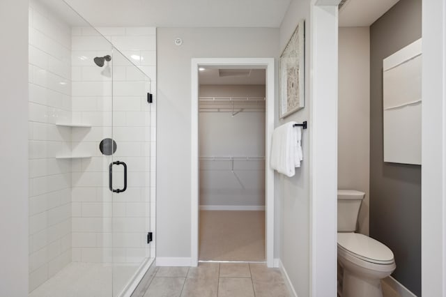 bathroom featuring toilet, an enclosed shower, and tile patterned flooring