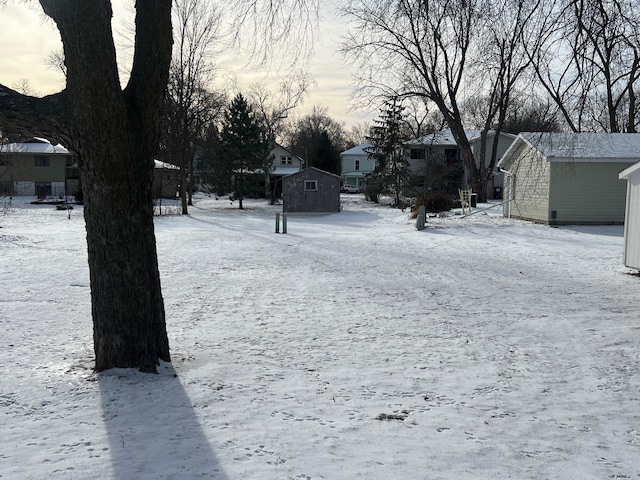 yard covered in snow with a storage unit