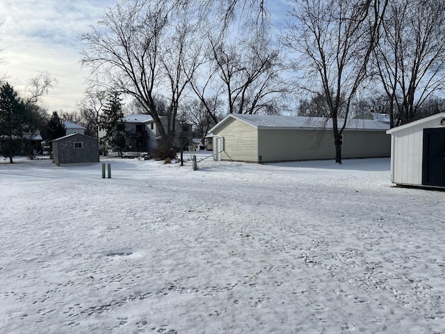 snowy yard featuring a shed