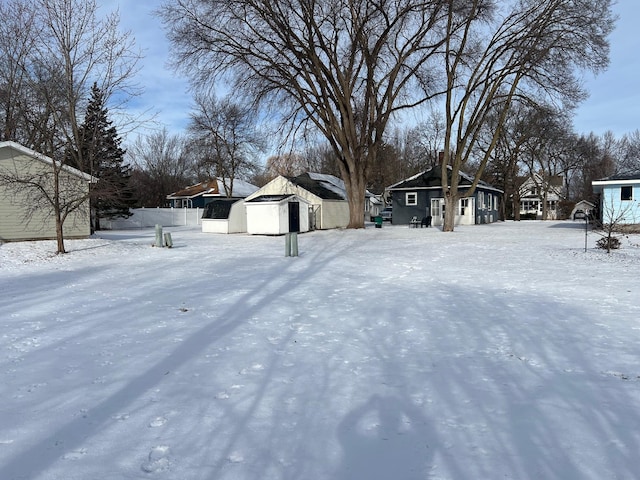 yard layered in snow featuring an outdoor structure