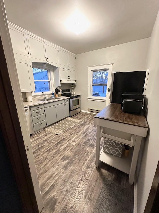 home office featuring a baseboard heating unit, wood-type flooring, and sink