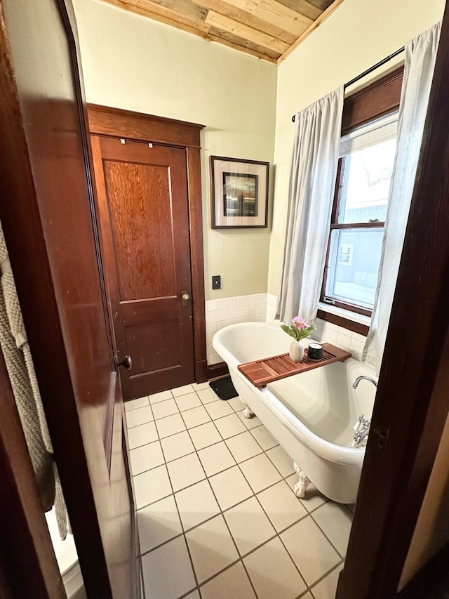 bathroom with tile patterned floors, a tub, and wooden ceiling