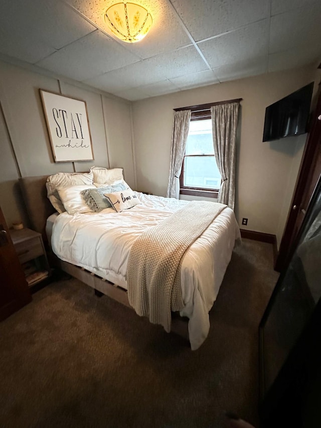 bedroom with carpet floors and a paneled ceiling