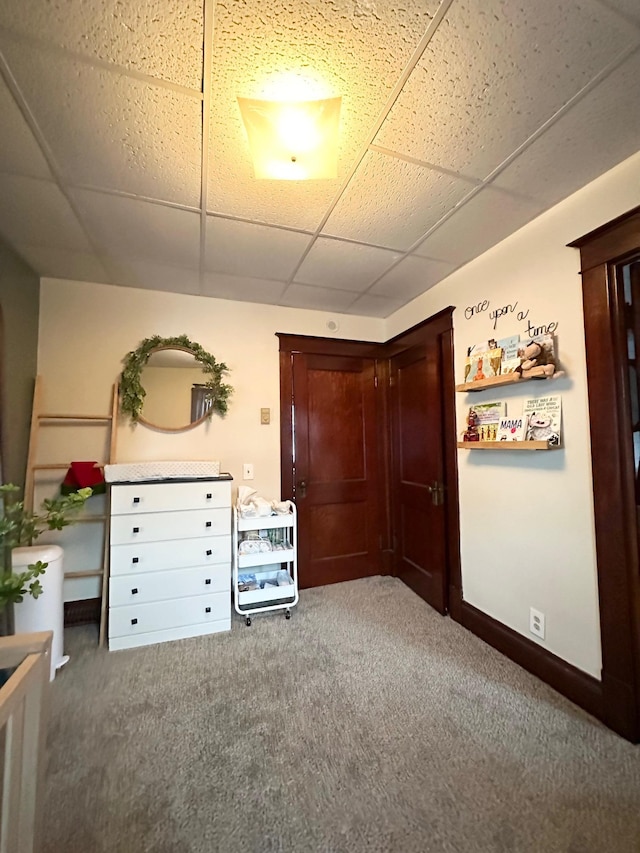 unfurnished bedroom featuring carpet and a drop ceiling