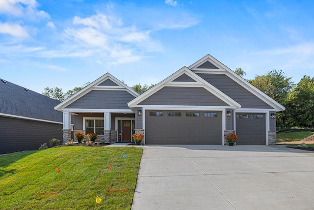 craftsman-style home with covered porch, a garage, and a front lawn