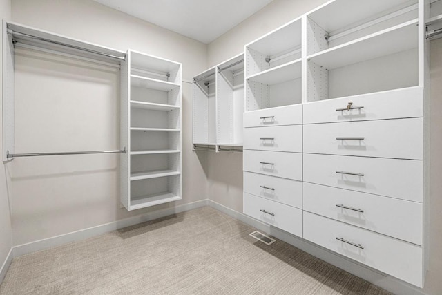 walk in closet with light colored carpet