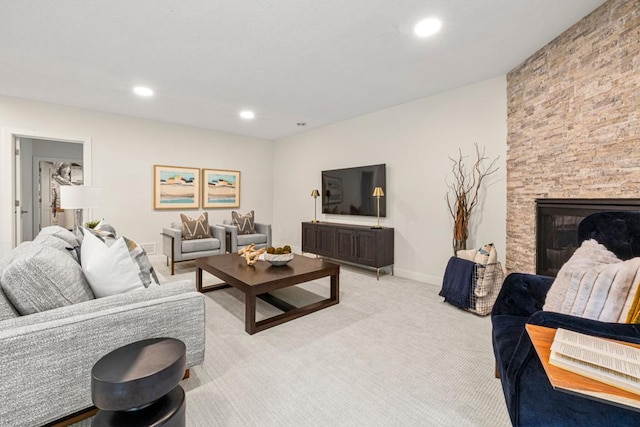 living room featuring light colored carpet and a stone fireplace