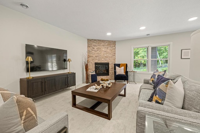 living room with light colored carpet and a stone fireplace