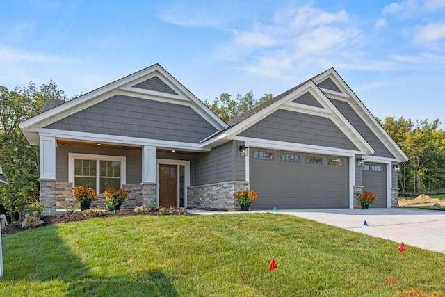 craftsman-style house featuring covered porch, a front yard, and a garage