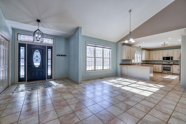 entrance foyer with a chandelier, baseboards, and light tile patterned floors