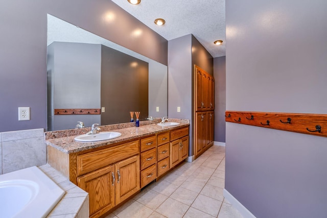 bathroom featuring a textured ceiling, double vanity, a sink, and tile patterned floors