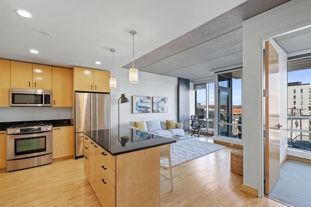 kitchen featuring appliances with stainless steel finishes, hanging light fixtures, a wealth of natural light, light hardwood / wood-style floors, and light brown cabinetry