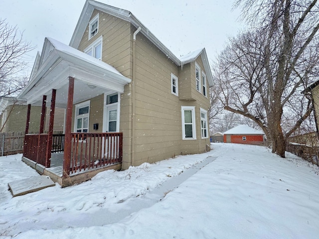 snow covered property featuring covered porch