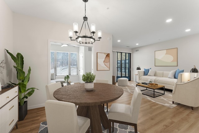 dining space with light wood-type flooring and a chandelier