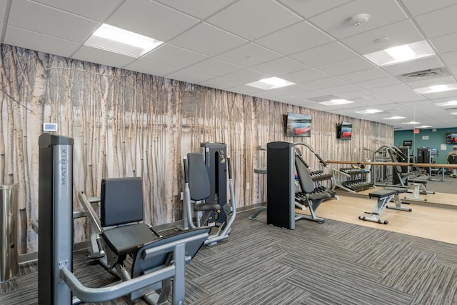 gym with carpet and a paneled ceiling