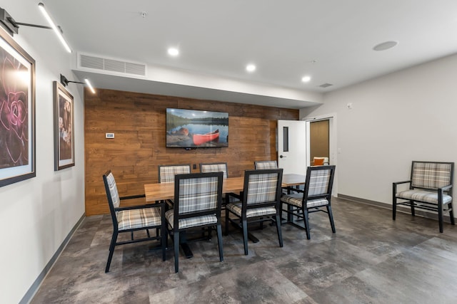 dining room featuring wood walls