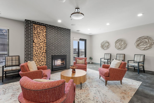 living room featuring a large fireplace and concrete floors