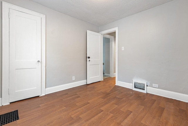 spare room with a textured ceiling and wood-type flooring