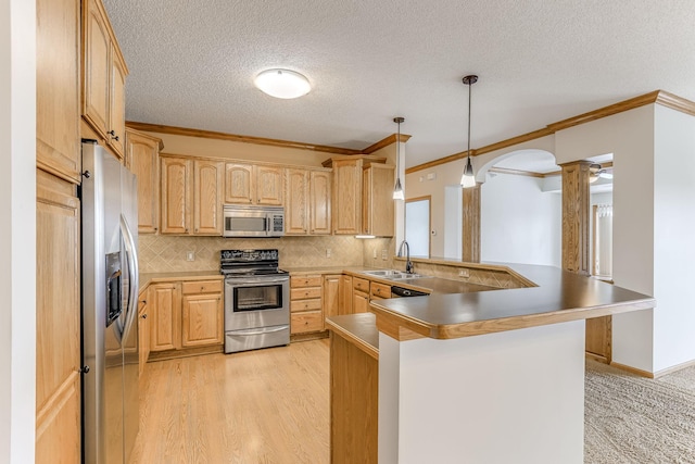 kitchen with stainless steel appliances, light brown cabinetry, sink, hanging light fixtures, and kitchen peninsula