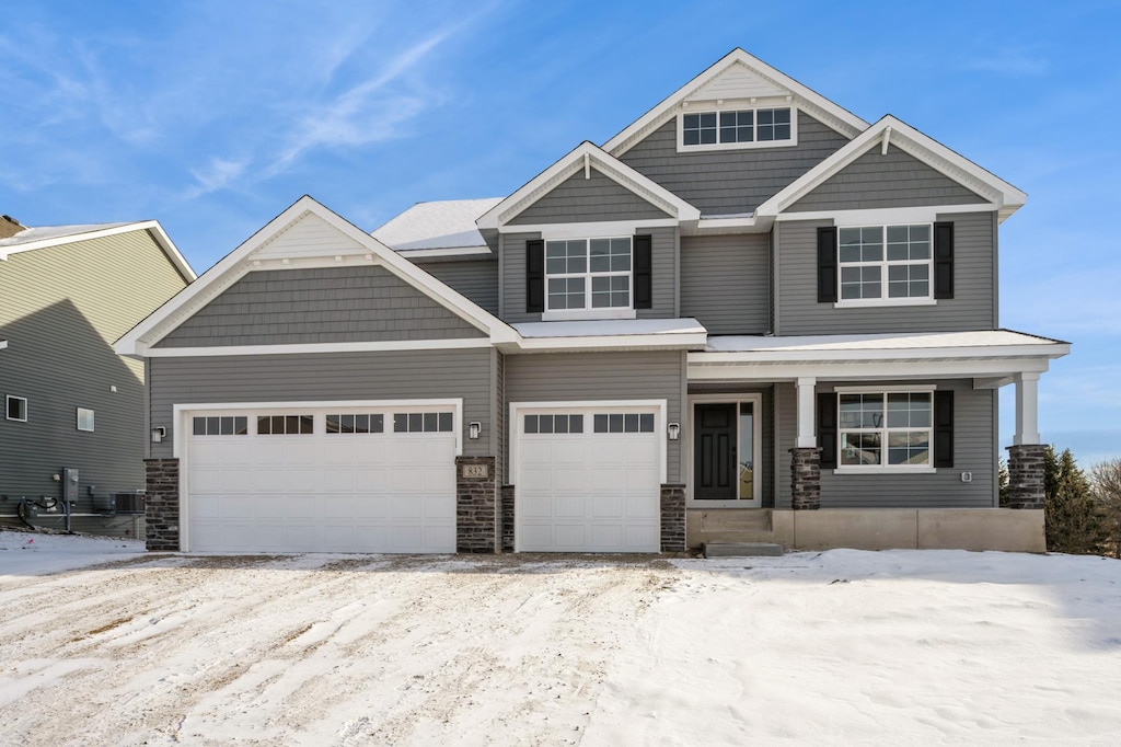 craftsman inspired home with central AC, a porch, and a garage