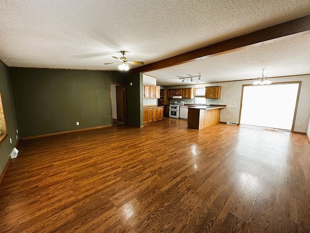 unfurnished living room with dark hardwood / wood-style flooring, ceiling fan with notable chandelier, beam ceiling, and a textured ceiling