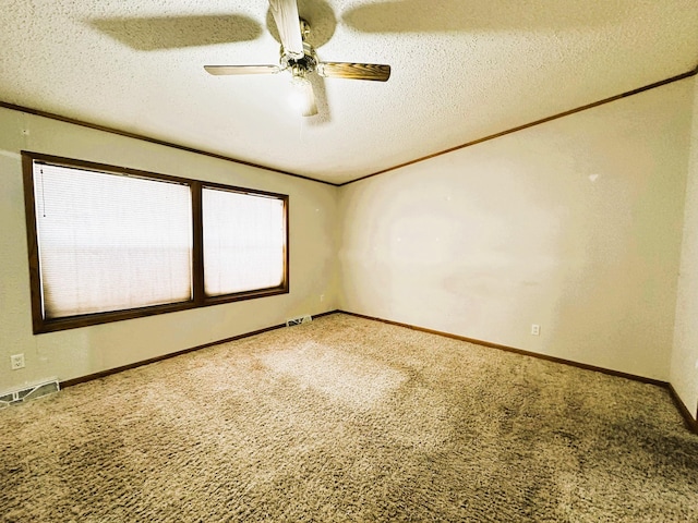 empty room with ceiling fan, carpet flooring, and a textured ceiling