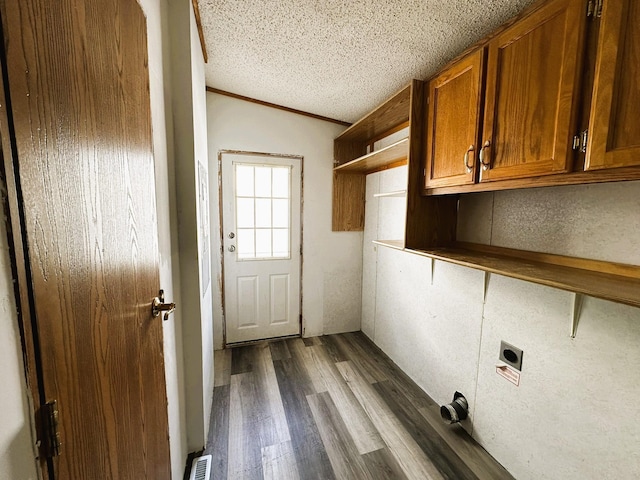 laundry room featuring cabinets, a textured ceiling, ornamental molding, dark hardwood / wood-style flooring, and electric dryer hookup