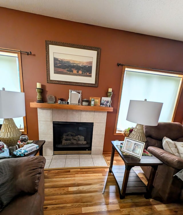 living room with a textured ceiling, a fireplace, and wood-type flooring