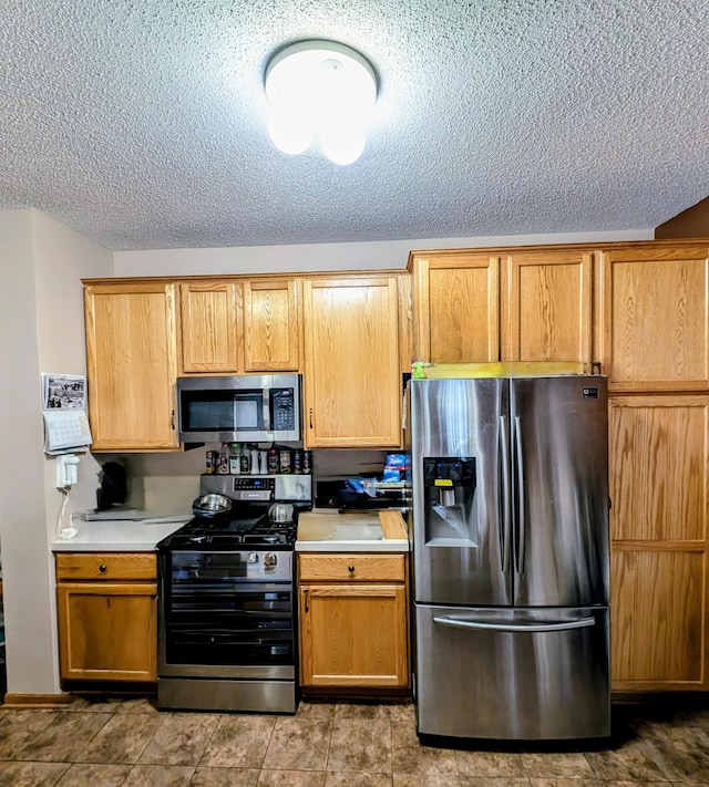 kitchen with stainless steel appliances and a textured ceiling