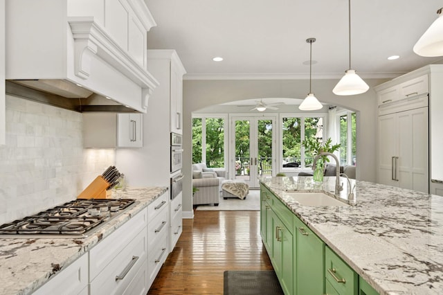 kitchen featuring ceiling fan, decorative backsplash, sink, and green cabinetry