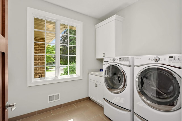 washroom featuring cabinets, separate washer and dryer, and light tile patterned floors