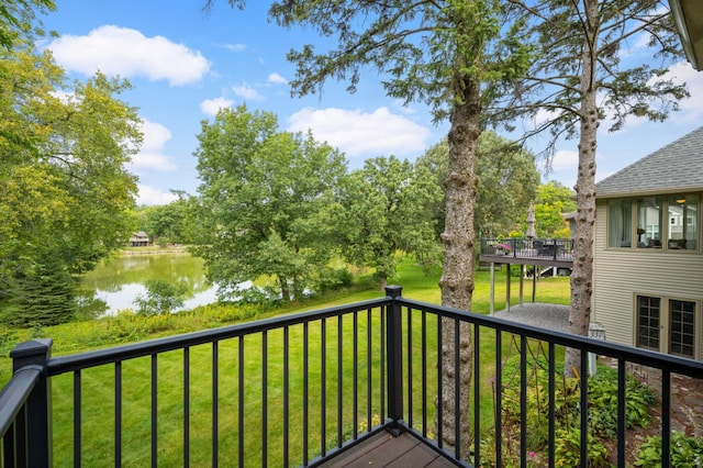 wooden terrace featuring a water view and a lawn