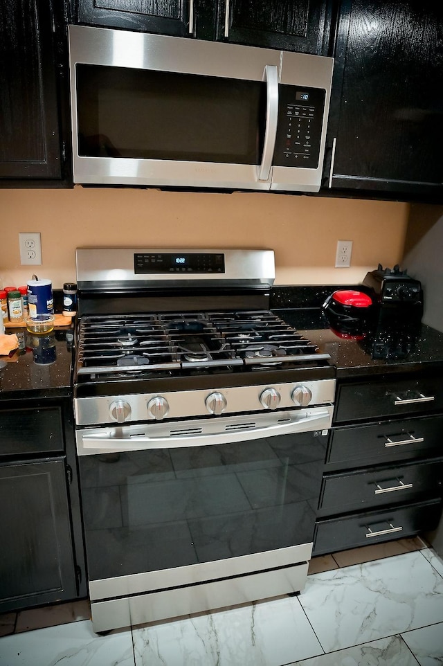 kitchen with stainless steel appliances and dark stone countertops