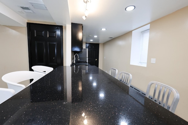 kitchen with sink and dark stone countertops